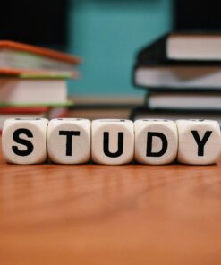 Close-up of study blocks and stacked books on a wooden desk, symbolizing education and learning.